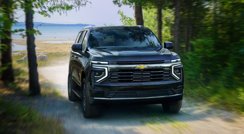 Black 2025 Chevy Tahoe for sale driving through a forest
