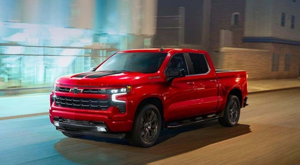 A red 2023 Chevy Silverado 1500 RST is shown driving after the owner searched 'sell my car.'