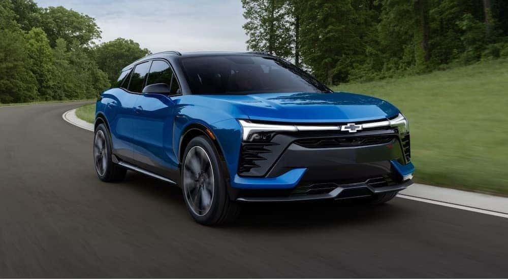 A blue 2024 Chevy Blazer is shown driving from a dealer with SUVs for sale.