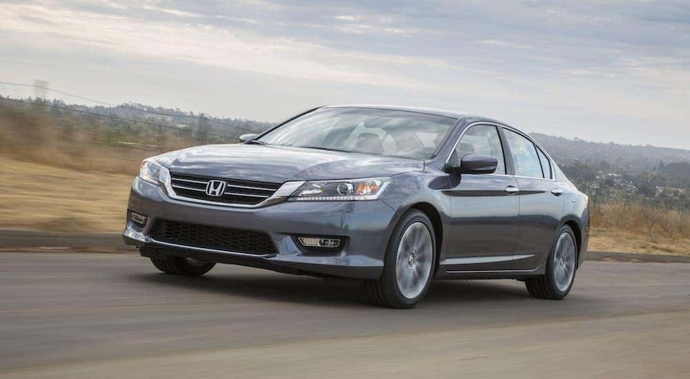 A silver 2015 Honda Accord driving down a road.