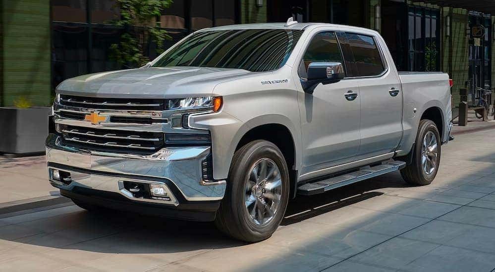A silver 2019 Chevy Silverado 1500 is shown on a city street after looking at used Chevy trucks for sale.