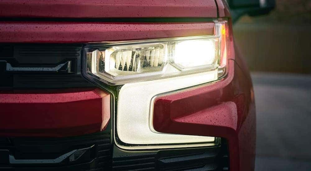 Headlight of a red 2026 Chevy Silverado 1500