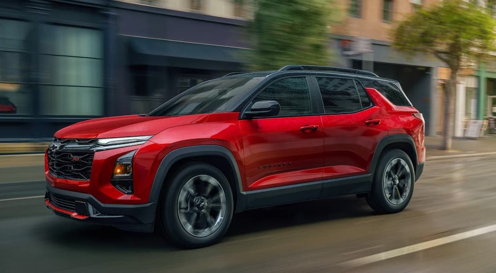 A red 2026 Chevy Equinox RS driving in a city.