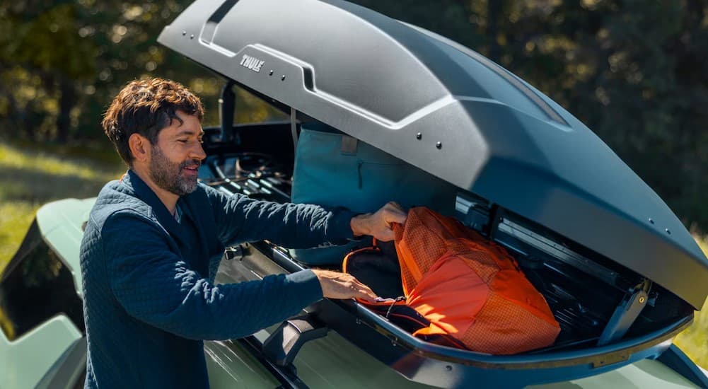 A person using the roof storage pod on a 2026 Chevy Equinox.