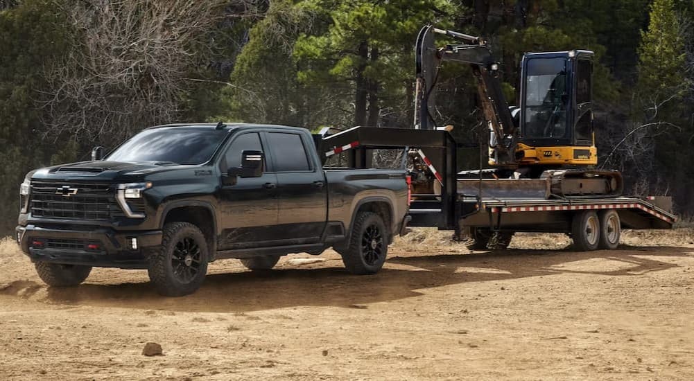 A black 2026 Chevy Silverado 3500 HD towing a trailer.