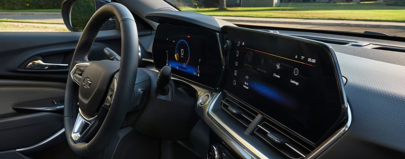 Interior view of a 2026 Chevy Trax infotainment system, steering wheel and digital gauge cluster.