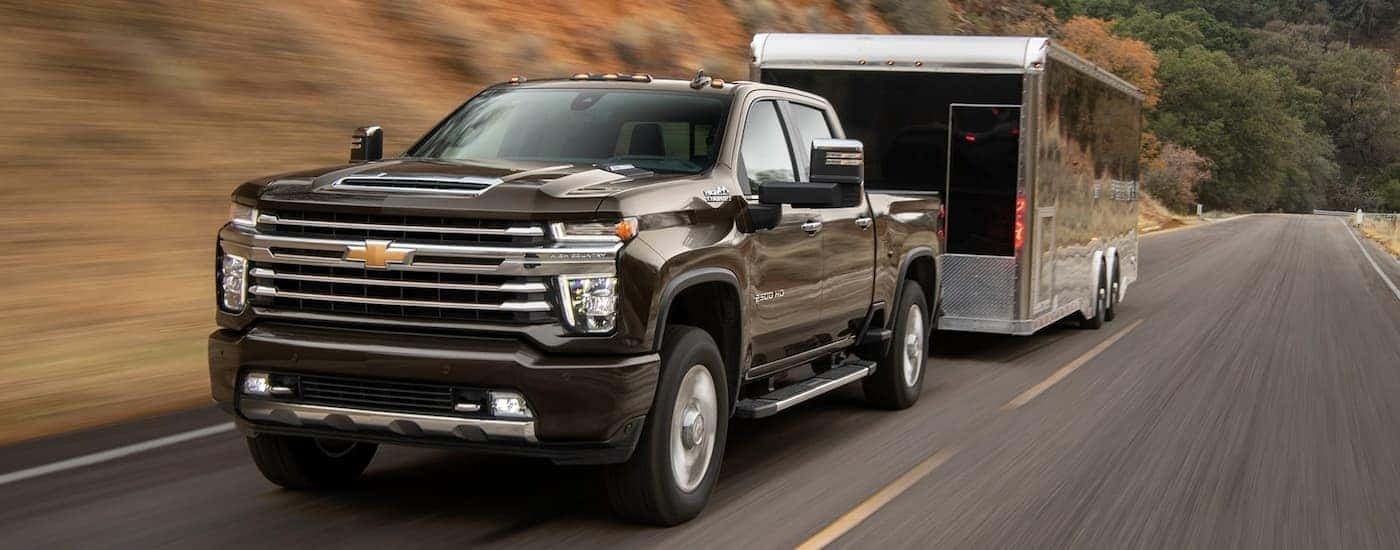 Brown 2024 Chevy Silverado 2500 High Country towing a camper