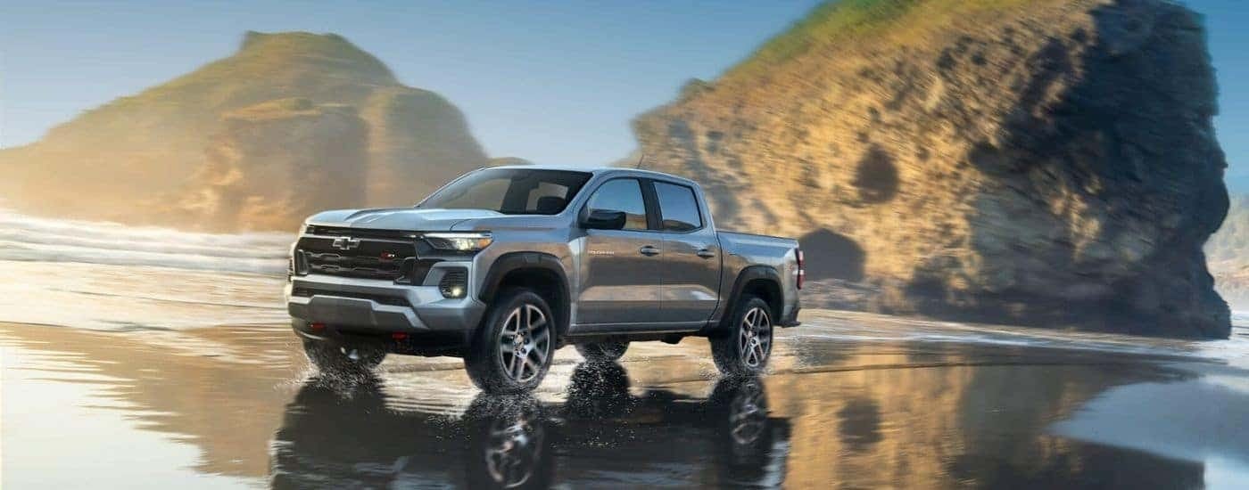 Silver 2023 Chevy Colorado is shown driving off-road after viewing used trucks for sale