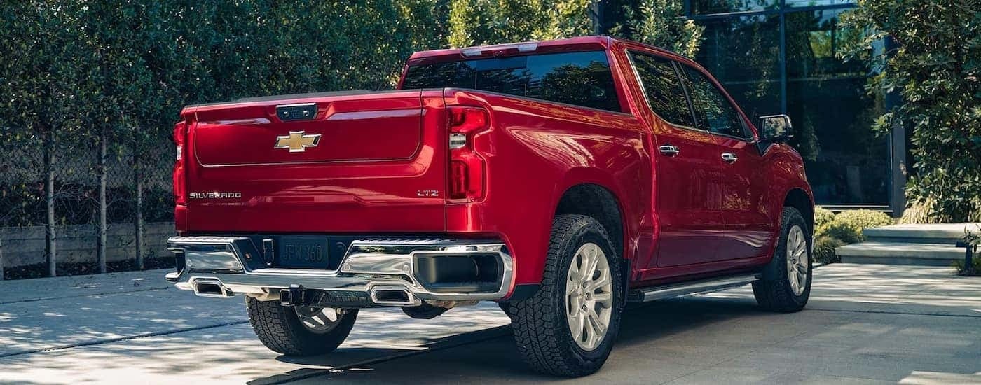 A red 2024 Chevy Silverado 1500 LTZ is parked in a driveway.