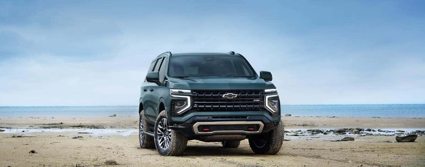 A green 2025 Chevy Tahoe Z71 is shown from the front at an angle.