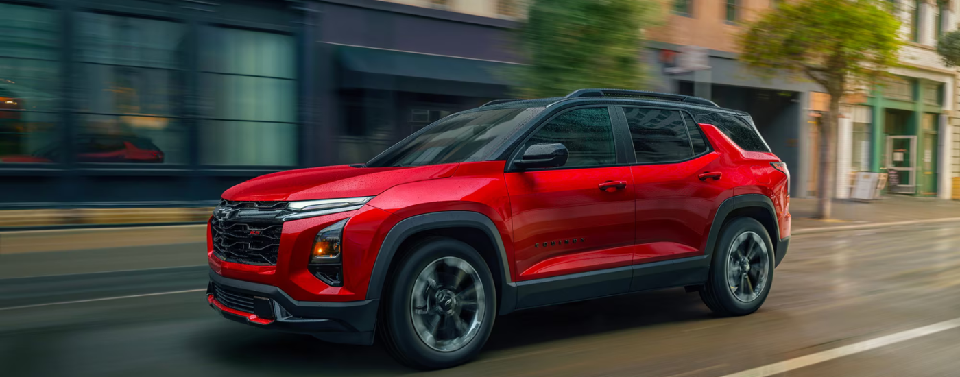 Red 2026 Chevy Equinox RS for sale near Hoover driving down a city street.