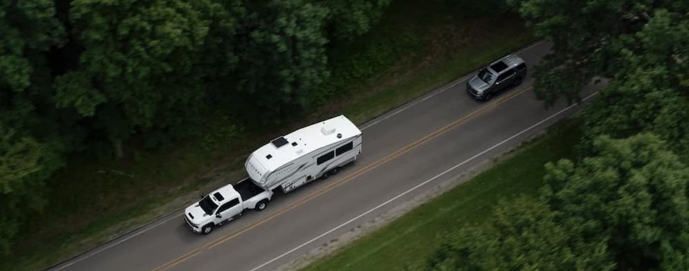 Aerial view of a white 2026 Chevy Silverado 2500 towing a trailer.