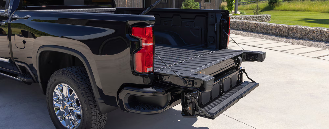 An open Multi-Flex tailgate of a black 2025 Chevy Silverado 2500 HD at a Chevy Silverado 2500 dealer.