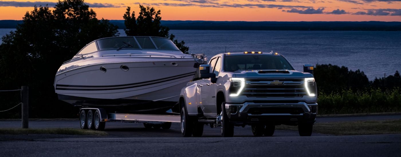 White 2026 Chevy Silverado 3500 HD LTZ towing a boat