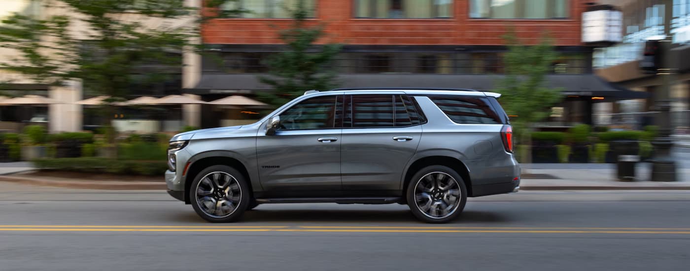 Silver 2026 Chevy Tahoe driving down a city street.