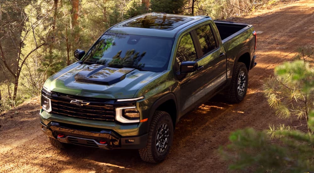Green 2027 Chevy Silverado 1500 driving in a forest