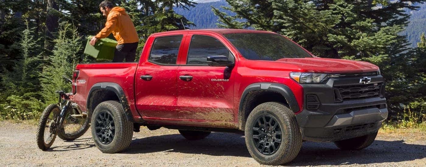 A red 2024 Chevy Colorado Trail Boss is parked on the side of a dirt road.