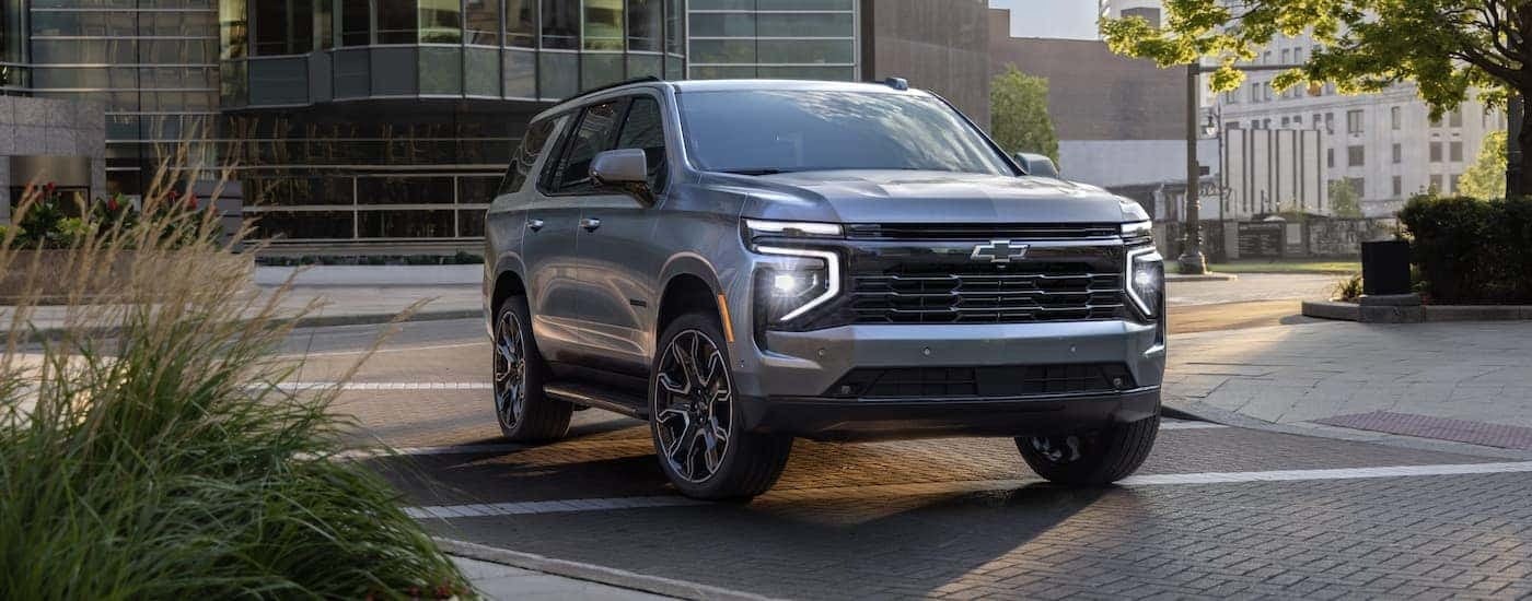 A silver 2025 Chevy Tahoe RST for sale near Hoover is driving on a city street.