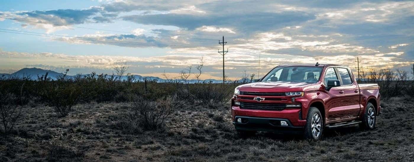 A red 2023 Chevy Silverado 1500 RST is shown parked on a field after leaving a Pelham Chevy dealer.