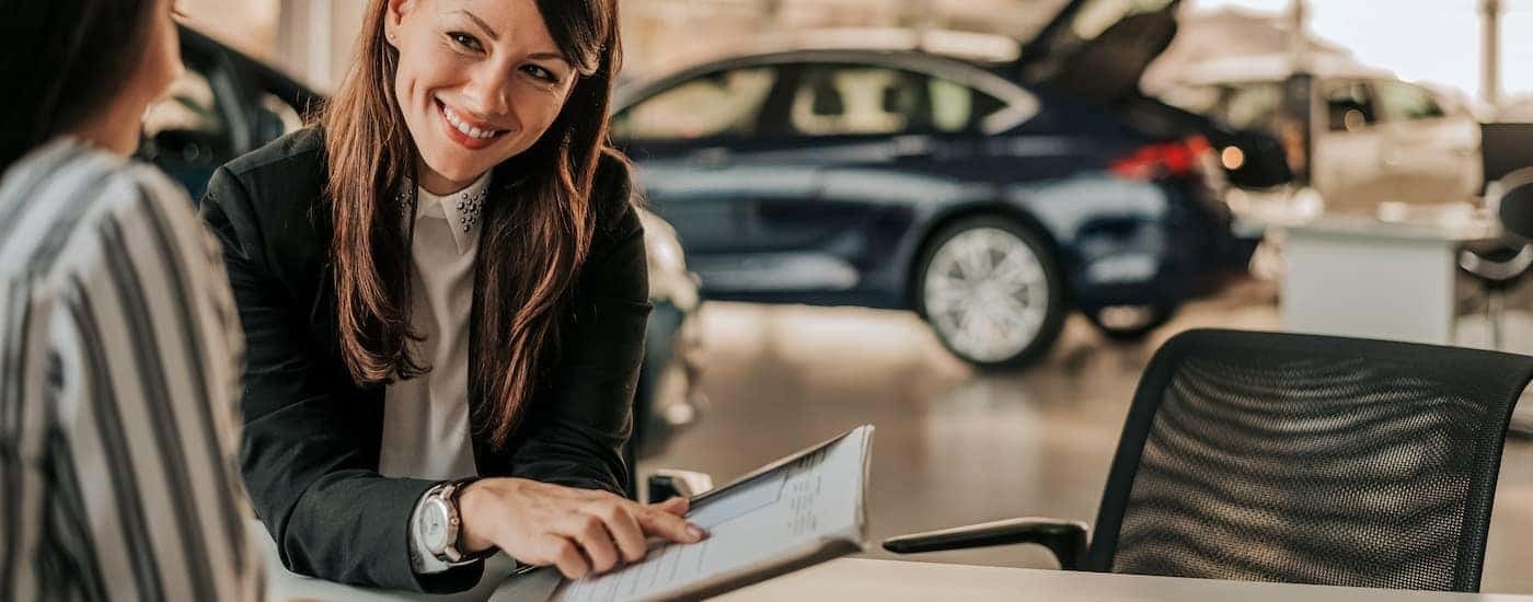 A person is shown going over paperwork at a Pelham Chevy dealer.