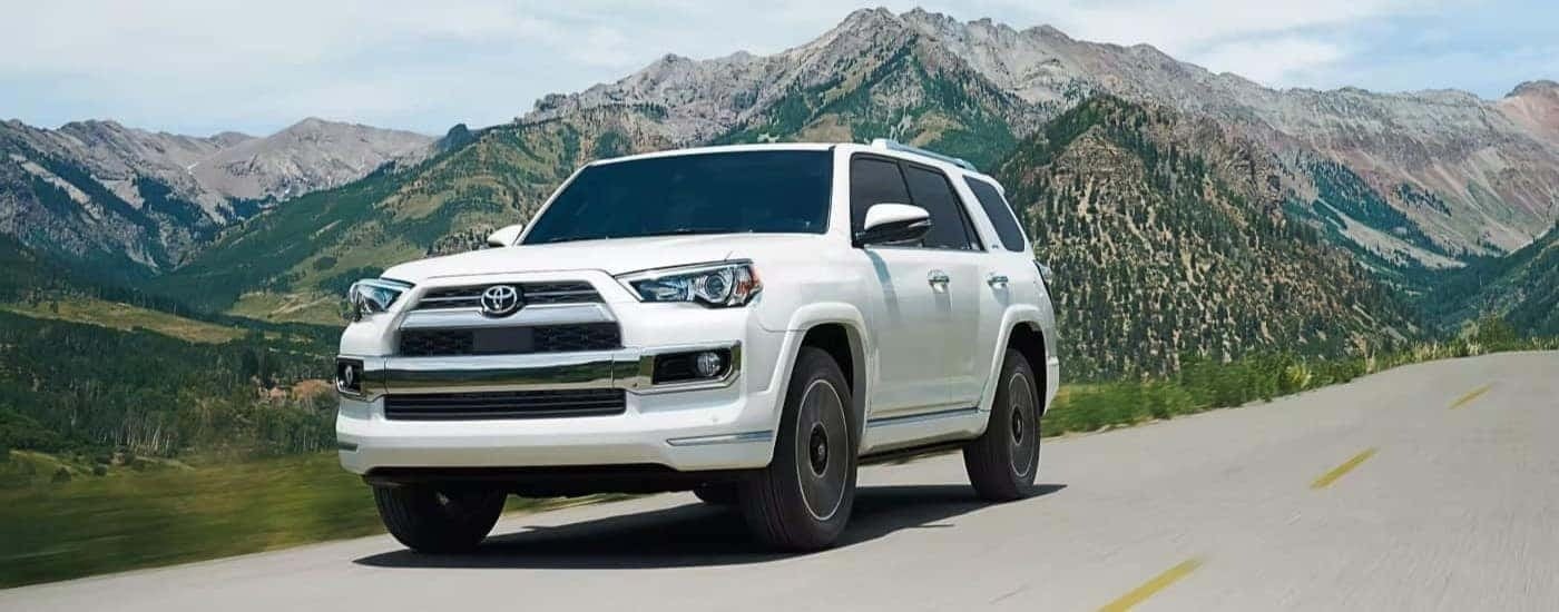 A white 2022 Toyota 4Runner is shown driving past a mountain.