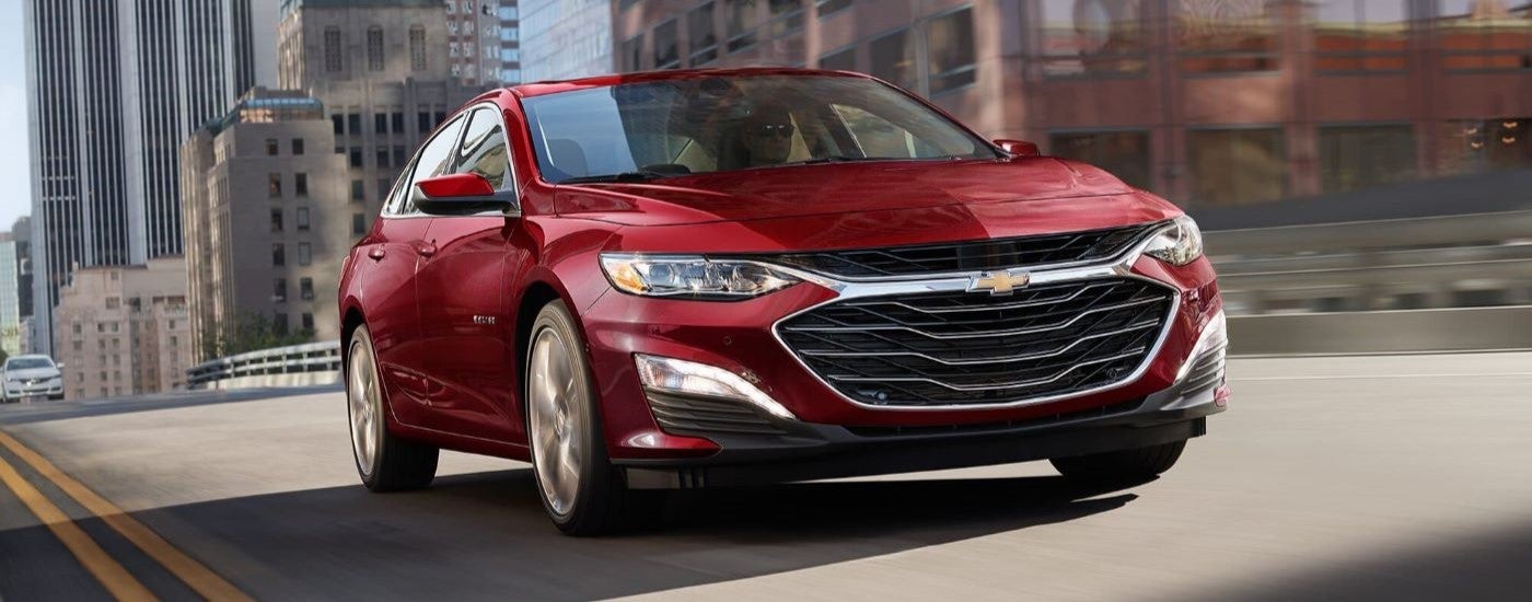 Red 2024 Chevy Malibu driving on a city street