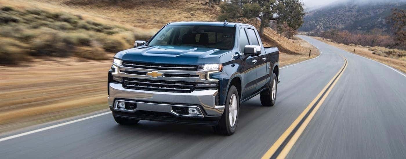 Blue 2020 Chevy Silverado 1500 driving down an empty road to see used Chevy Silverado's for sale